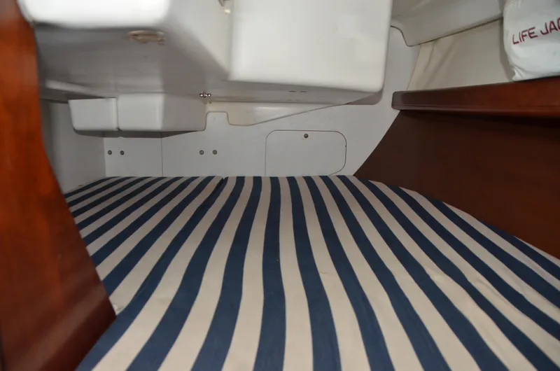 Slide: The Image of Interior cabin of 2002 Beneteau First 36.7 with striped bedding and wooden accents. - 29