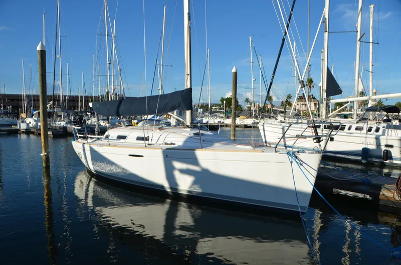 Slide: The Image of 2002 Beneteau First 36.7 sailboat docked in a marina under clear blue skies. - 3