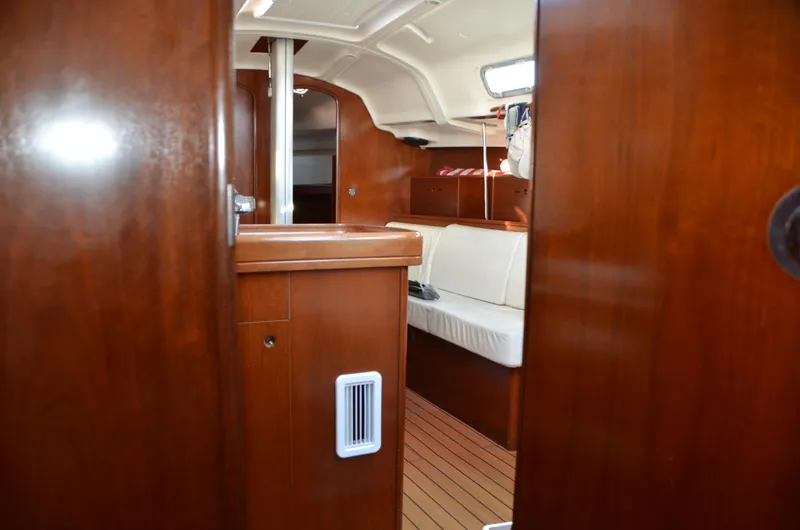 Slide: The Image of Interior of 2002 Beneteau First 36.7 sailboat, featuring wooden cabinetry and white seating. - 32