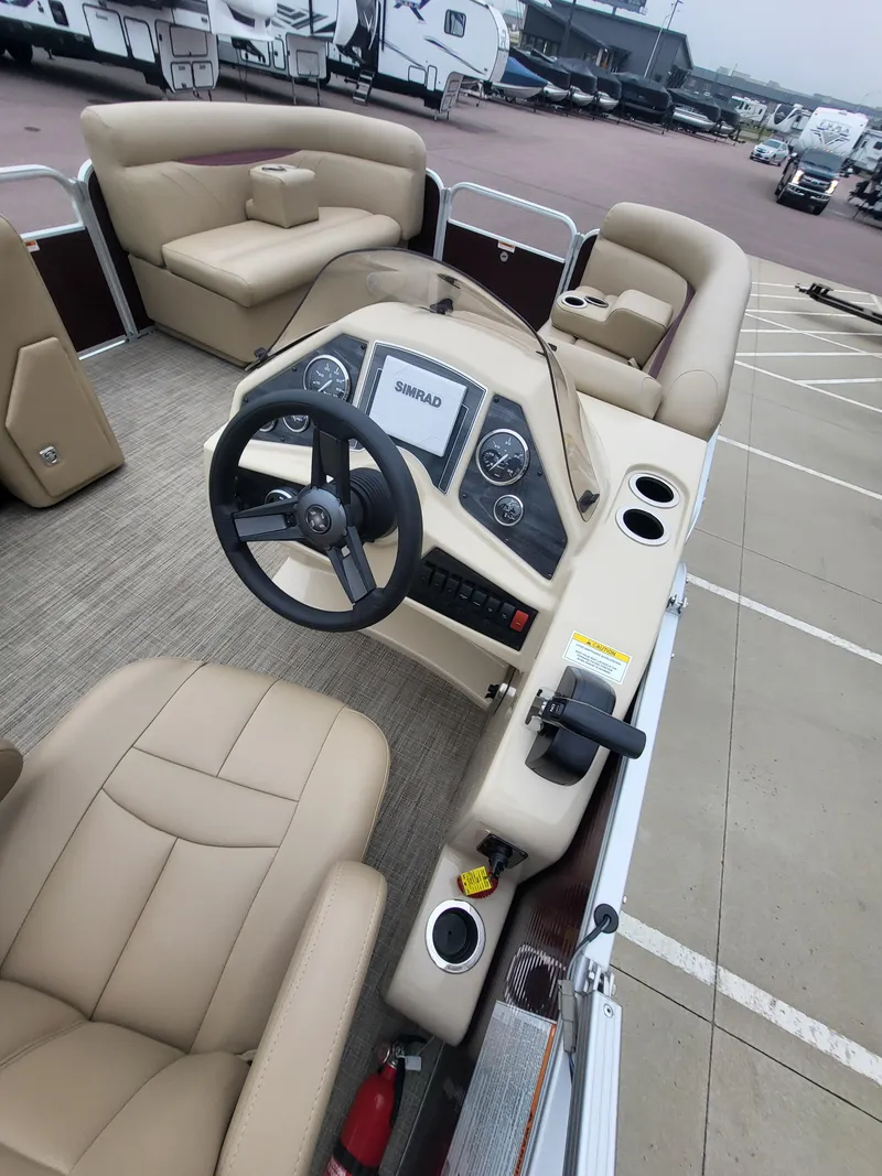 Slide: The Image of 2018 Sweetwater CRUISER boat interior with beige seating and steering console. - 10