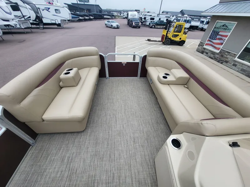 Slide: The Image of 2018 Sweetwater CRUISER pontoon boat with beige seating, parked in a dealership lot. - 12