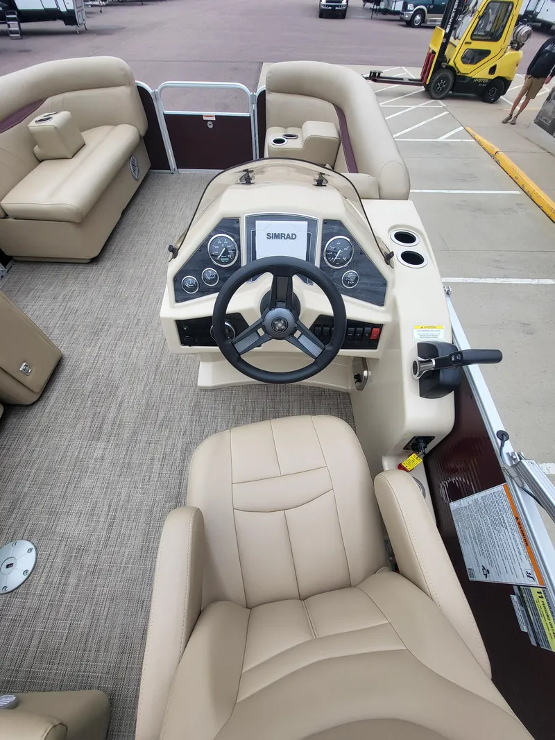 Slide: The Image of 2018 Sweetwater CRUISER boat interior with beige seating and steering console. - 9