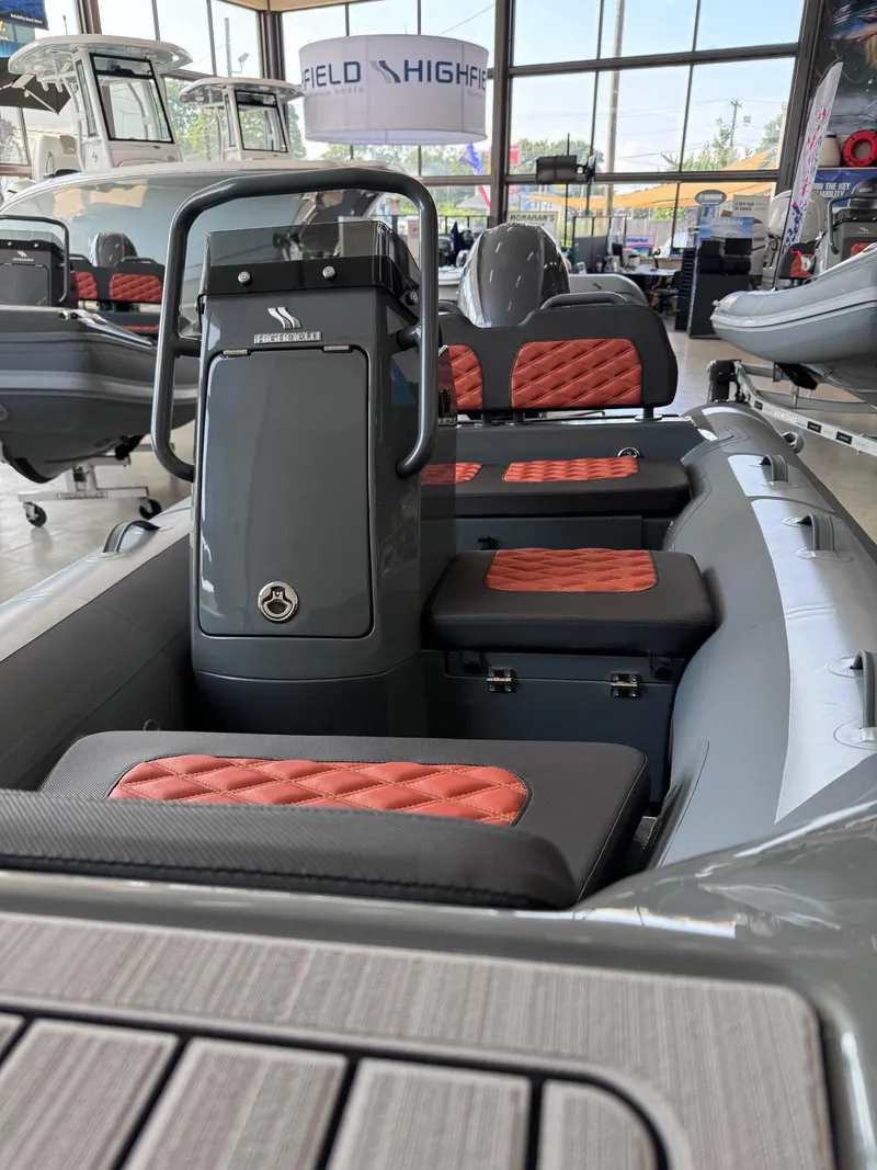 Slide: The Image of 2024 Highfield Sport 330 boat interior with red and black seating in showroom. - 4