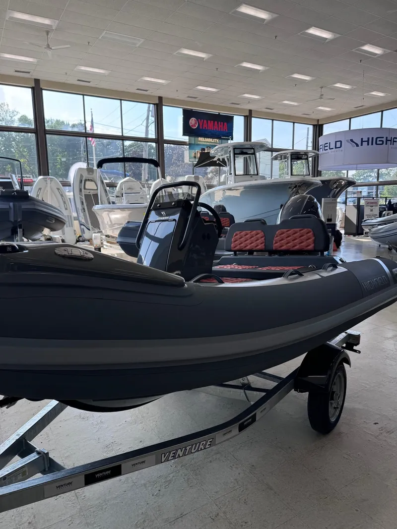 Slide: The Image of 2024 Highfield Sport 330 inflatable boat displayed in a showroom on a trailer. - 5