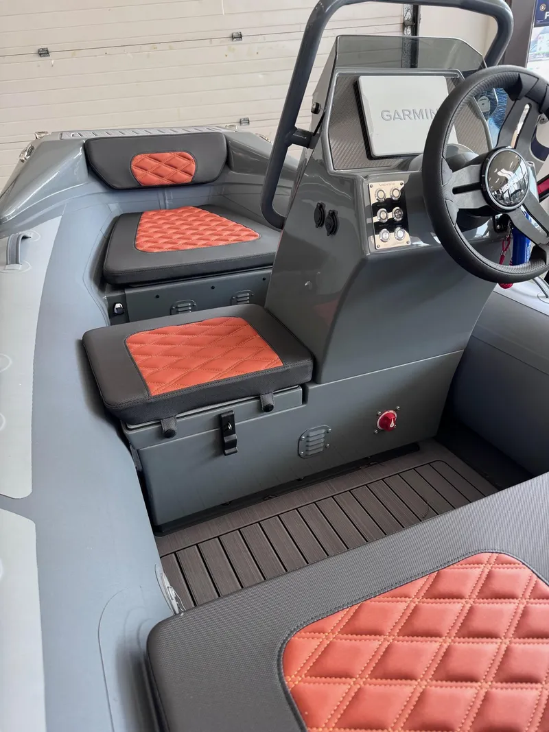Slide: The Image of 2024 Highfield Sport 330 boat interior with red quilted seats and modern steering console. - 6
