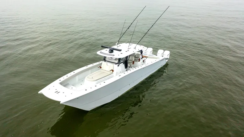 Slide: The Image of 2023 Freeman 42 LR boat on calm water, equipped with fishing rods. - 4