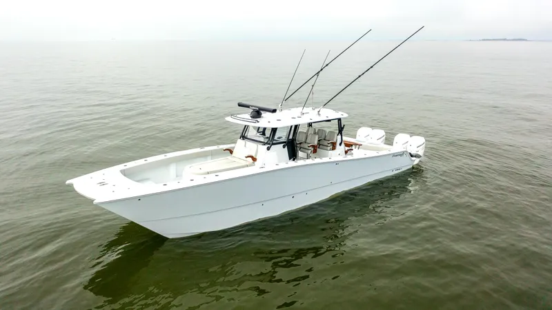 Slide: The Image of 2023 Freeman 42 LR boat on calm water, featuring sleek design and multiple fishing rods. - 5
