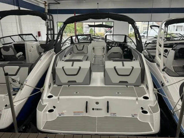 Slide: The Image of 2025 Yamaha Boats AR220, sleek design, spacious seating, modern interior, displayed in showroom. - 1