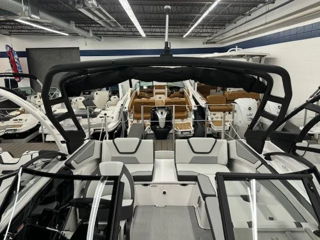 Slide: The Image of 2025 Yamaha Boats AR220 in showroom, sleek design with modern seating and black canopy. - 4
