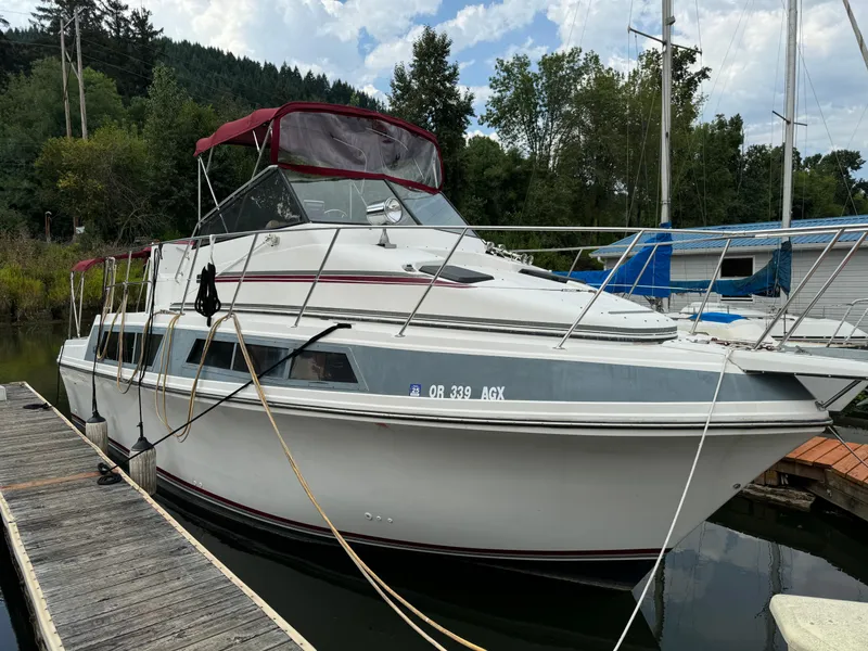 The Image of 1986 Carver Mariner 3297 docked, featuring a white hull and red canopy. - 0