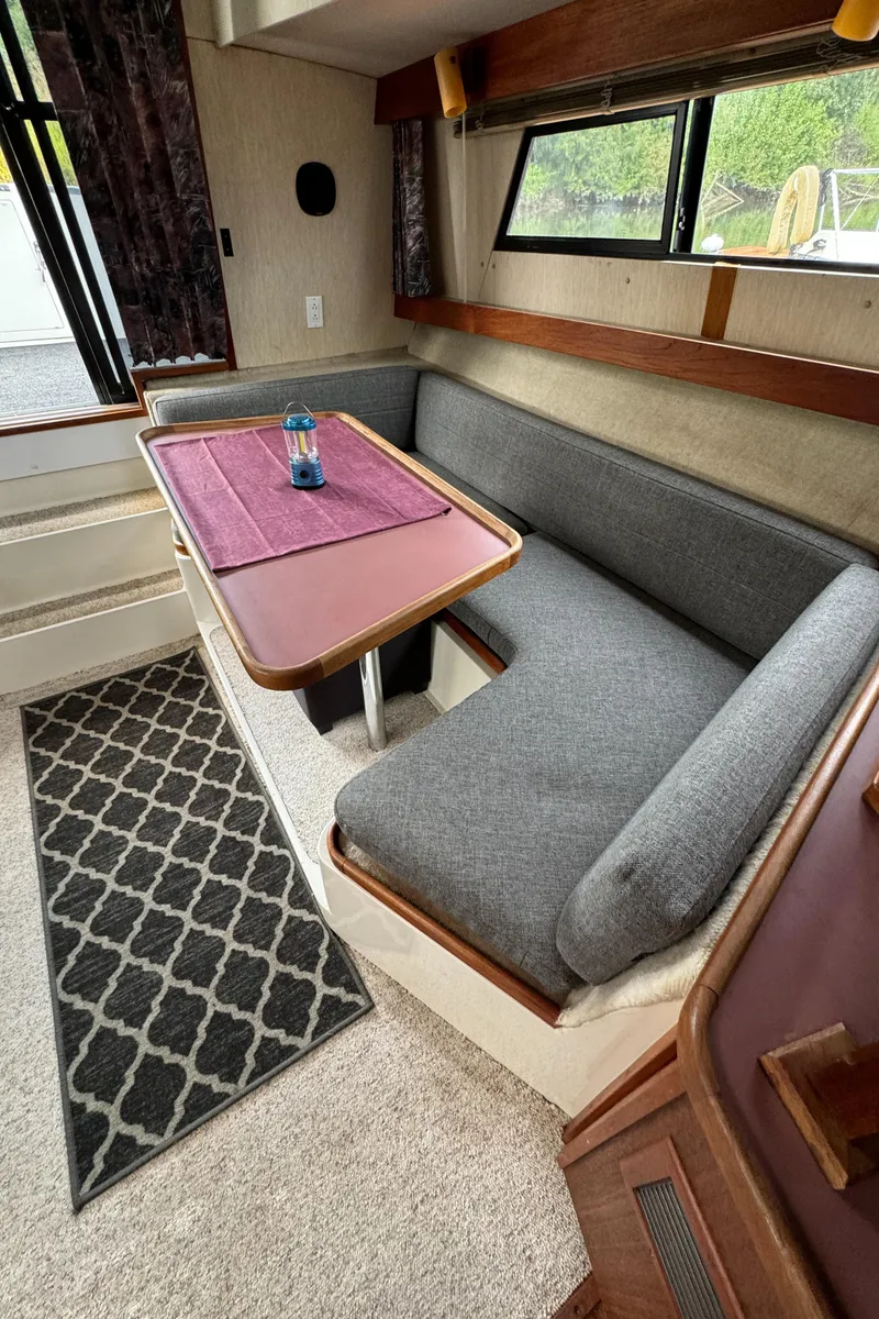 Slide: The Image of 1986 Carver Mariner 3297 interior with gray seating, table, and window view. - 11