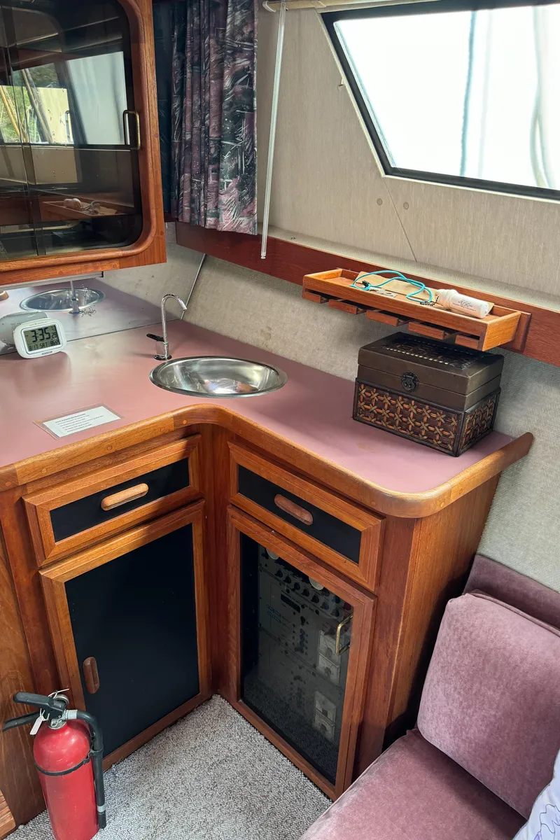 Slide: The Image of 1986 Carver Mariner 3297 interior with kitchenette, sink, and wooden cabinetry. - 14