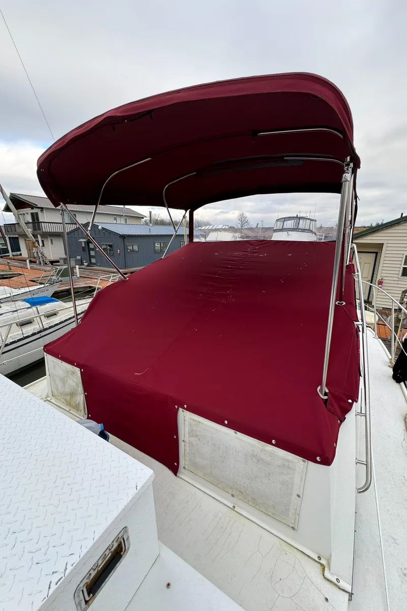 Slide: The Image of 1986 Carver Mariner 3297 with red canopy, docked at marina. - 21