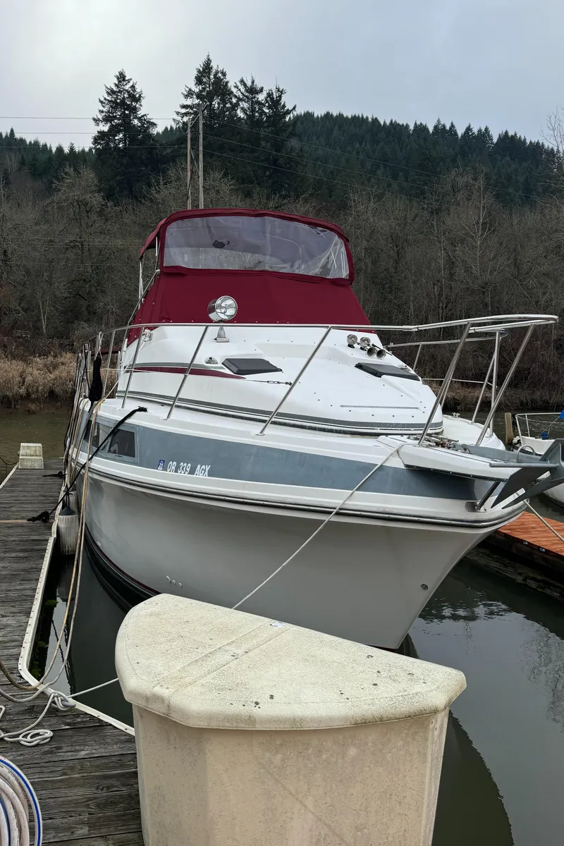 Slide: The Image of 1986 Carver Mariner 3297 docked, featuring a red canopy and sleek design. - 22