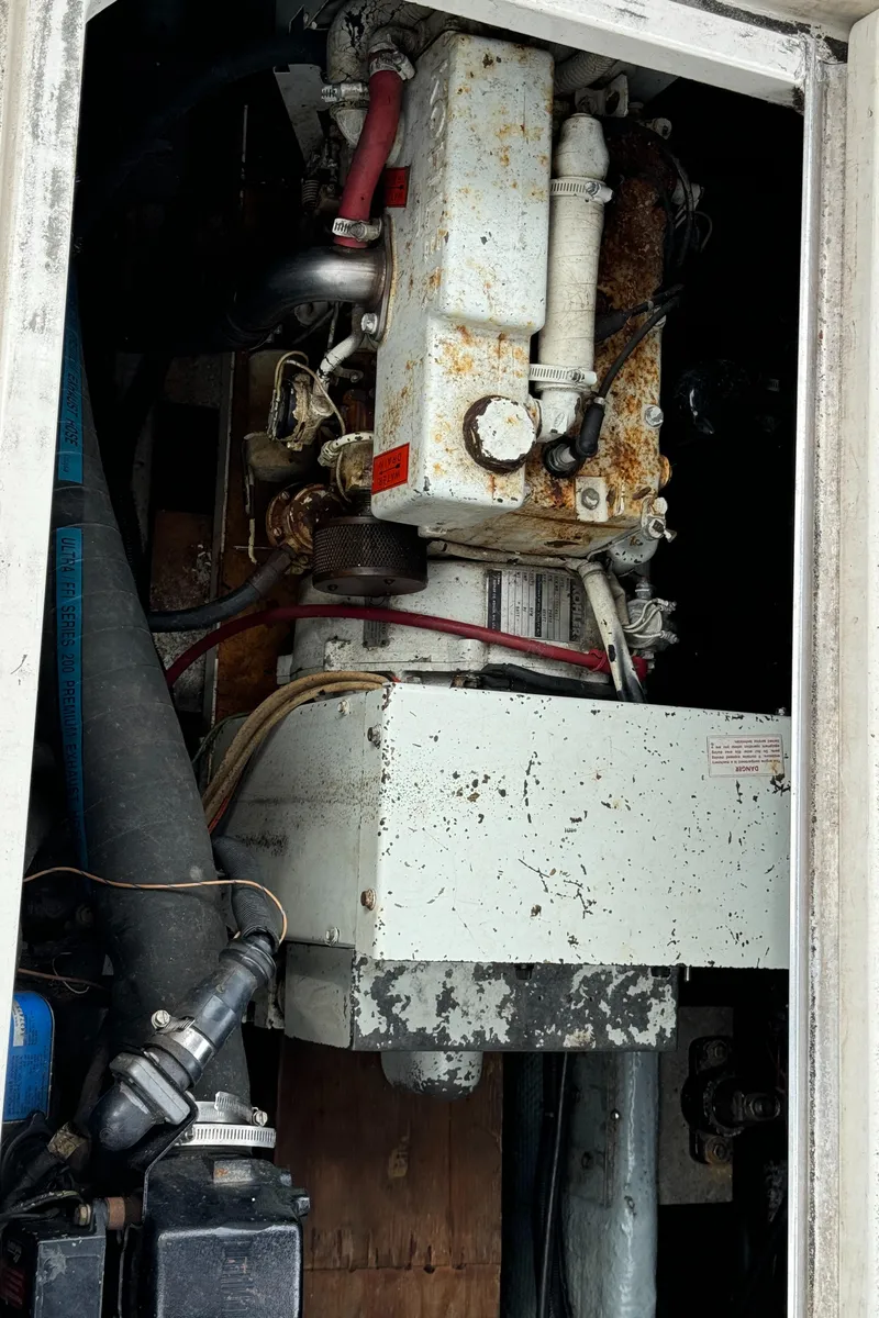 Slide: The Image of Engine compartment of a 1986 Carver Mariner 3297, showing mechanical components and rust. - 6