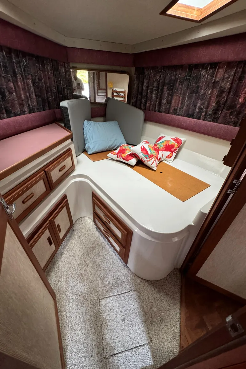Slide: The Image of 1986 Carver Mariner 3297 cabin interior with bed, storage, and decorative pillows. - 7