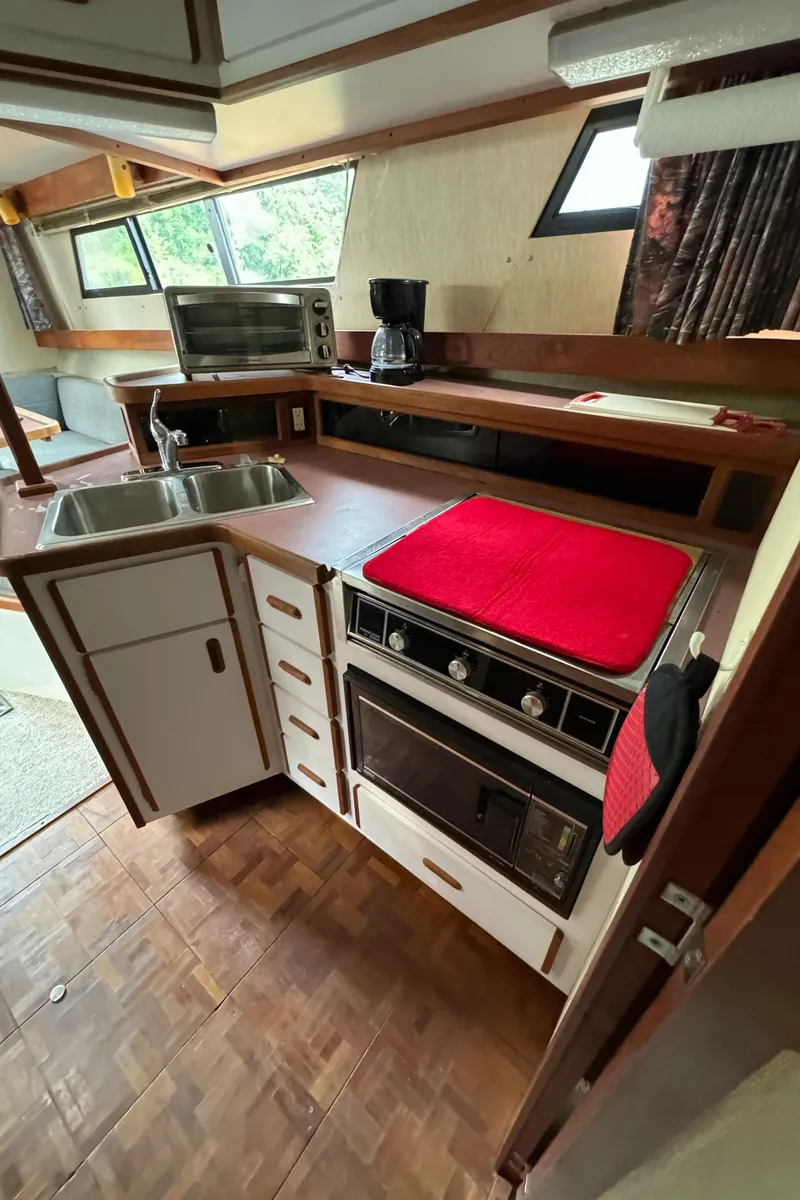 Slide: The Image of 1986 Carver Mariner 3297 kitchen with stove, sink, and microwave. - 9