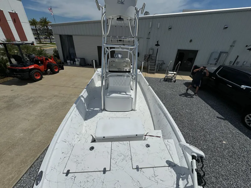 Slide: The Image of 2023 Blazer Bay 2400 boat with white deck, parked outside a building. - 15