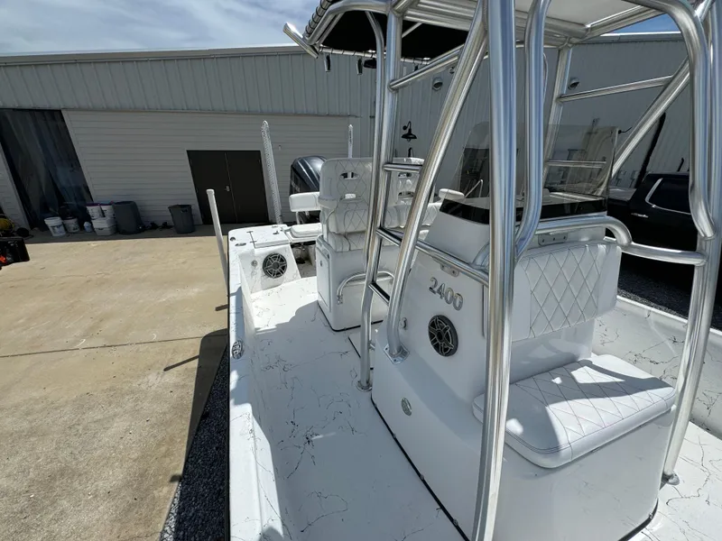 Slide: The Image of 2023 Blazer Bay 2400 boat with sleek design and modern seating, parked outdoors. - 19