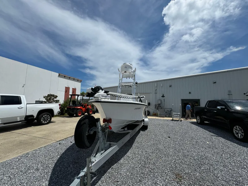 Slide: The Image of 2023 Blazer Bay 2400 boat on trailer in outdoor lot under blue sky. - 2