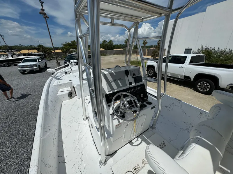 Slide: The Image of 2023 Blazer Bay 2400 boat with sleek console and steering wheel, parked outdoors. - 21