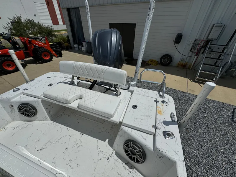 Slide: The Image of 2023 Blazer Bay 2400 boat with white seating and speakers, parked outdoors. - 24