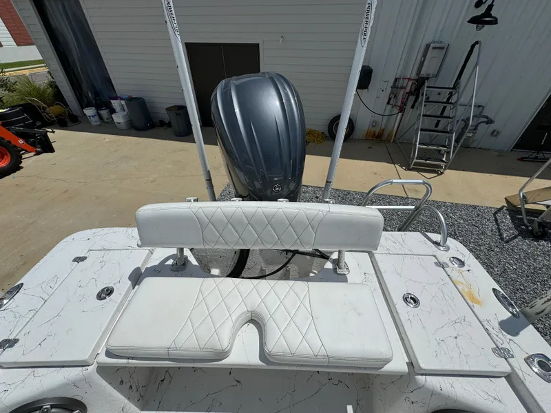 Slide: The Image of 2023 Blazer Bay 2400 boat with white seating and outboard motor in a marina setting. - 25