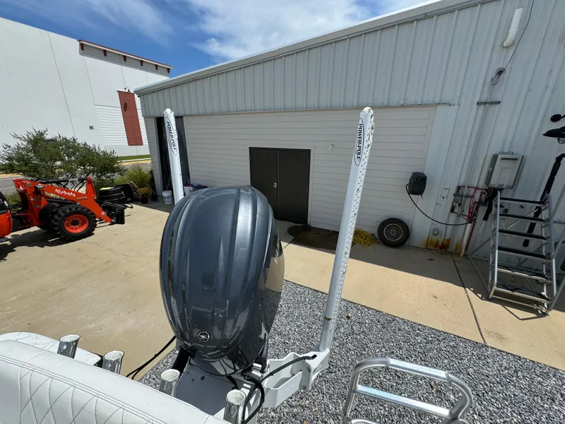 Slide: The Image of 2023 Blazer Bay 2400 boat with outboard motor near a warehouse. - 26