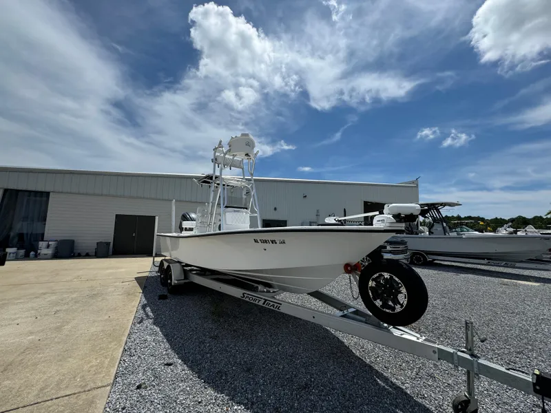 Slide: The Image of 2023 Blazer Bay 2400 boat on trailer, parked outside under a partly cloudy sky. - 3