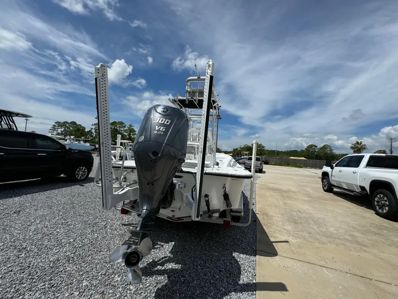 Slide: The Image of 2023 Blazer Bay 2400 boat with powerful outboard motor, parked on gravel under a blue sky. - 8