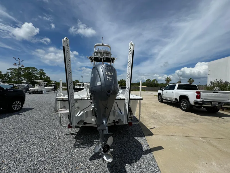 Slide: The Image of 2023 Blazer Bay 2400 boat with 300 V6 engine, parked outdoors on gravel. - 9