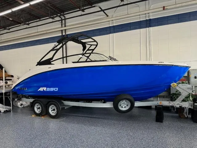 The Image of 2025 Yamaha AR250 boat in showroom, blue hull, on trailer. - 0