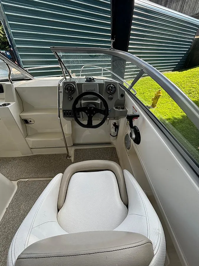 Slide: The Image of 2014 Bayliner 642 Cuddy boat interior with steering wheel and seating. - 11
