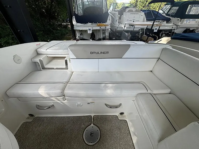 Slide: The Image of 2014 Bayliner 642 Cuddy boat interior with white seating and storage compartments. - 14