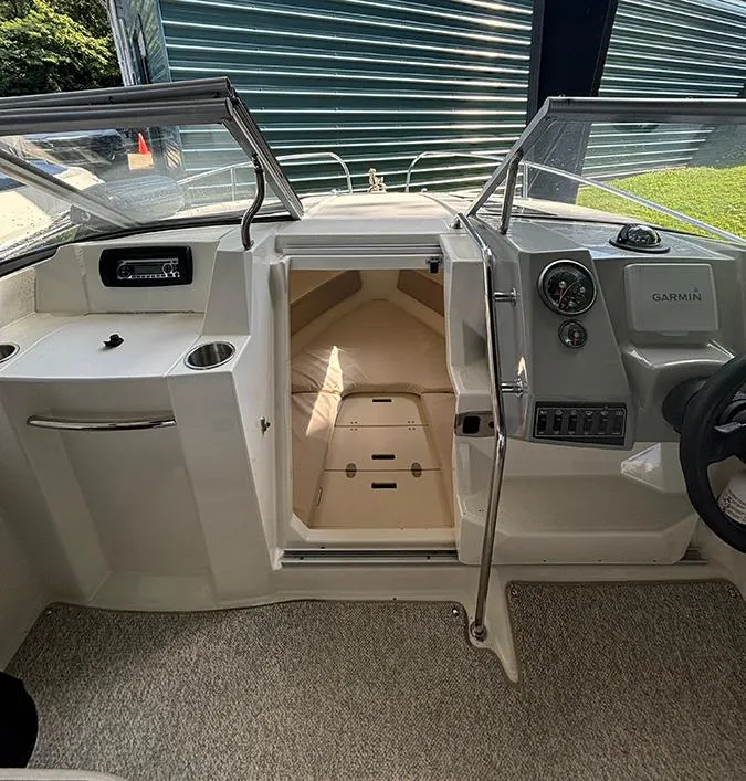 Slide: The Image of 2014 Bayliner 642 Cuddy interior with steering wheel, dashboard, and cabin entrance. - 6