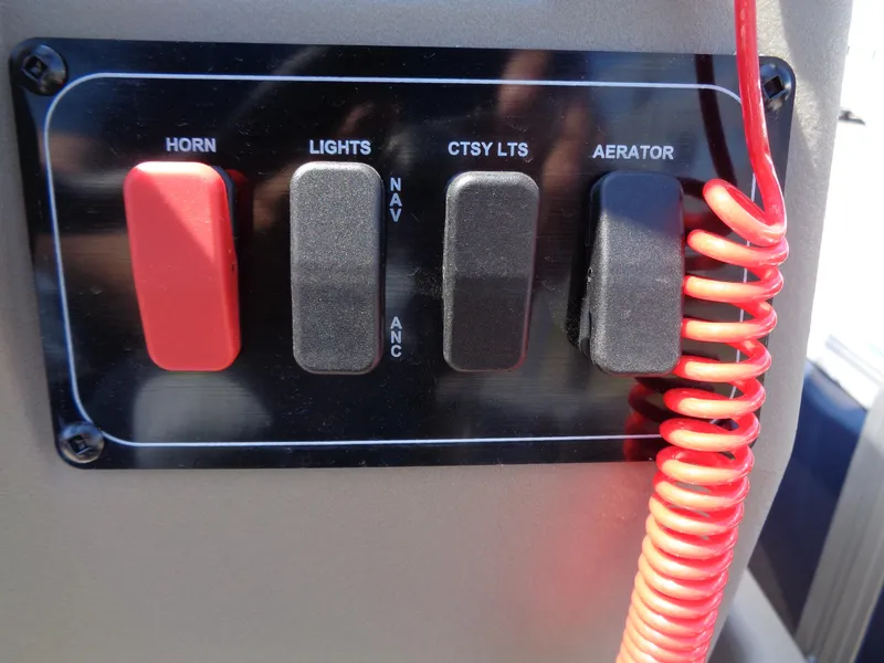 Slide: The Image of Control panel of 2025 Sun Tracker Bass Buggy 16 XL Select with switches and coiled red cord. - 5