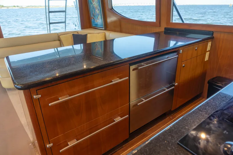 Slide: The Image of Luxurious kitchen interior of 2005 Hatteras 54 Convertible yacht with sleek cabinetry and ocean view. - 16
