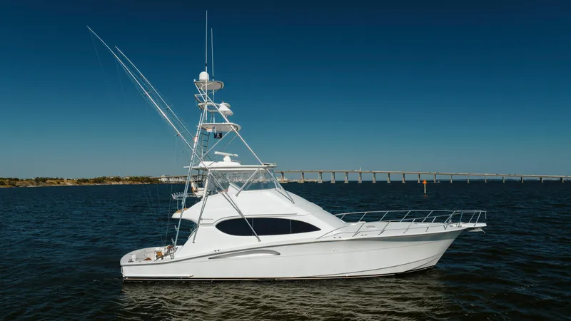 Slide: The Image of 2005 Hatteras 54 Convertible yacht on open water with bridge in background. - 2