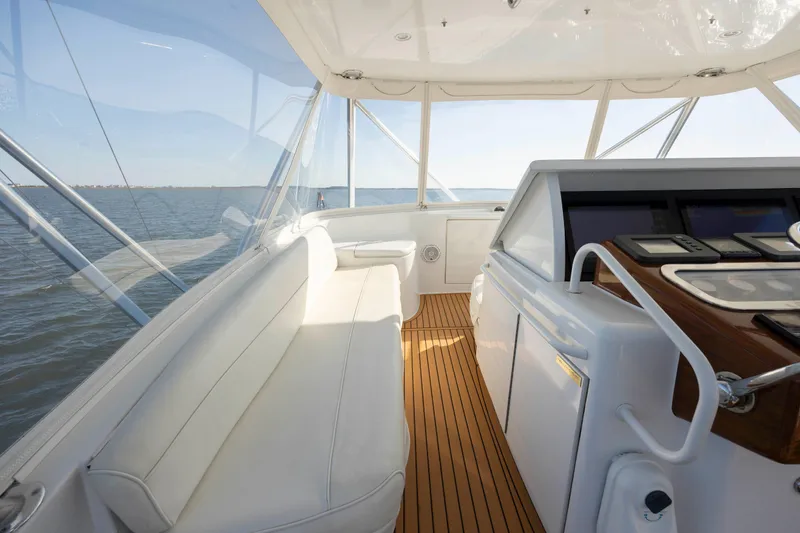 Slide: The Image of 2005 Hatteras 54 Convertible yacht interior with white seating and wooden flooring. - 22