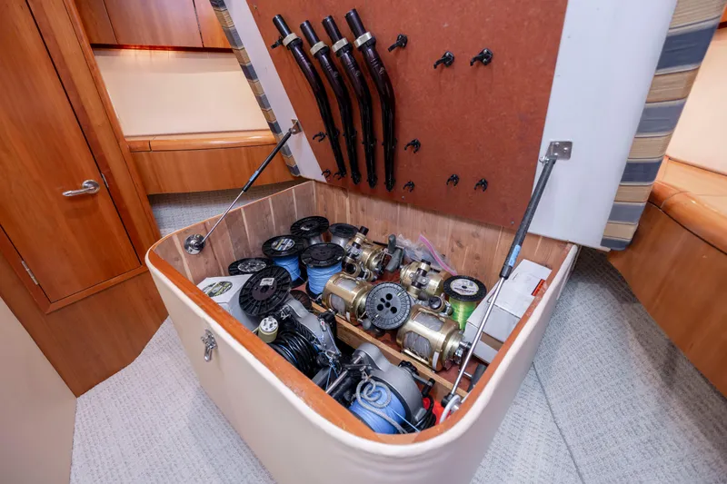 Slide: The Image of Storage compartment with fishing reels on a 2005 Hatteras 54 Convertible yacht. - 25