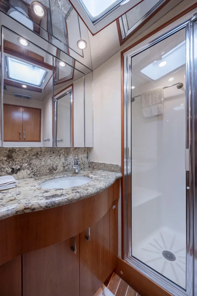 Slide: The Image of Luxurious bathroom in 2005 Hatteras 54 Convertible yacht with granite countertop and glass shower. - 29
