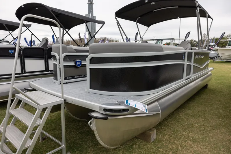 The Image of 2025 Premier 220 Sunscape RF pontoon boat displayed on grass with boarding ladder. - 0