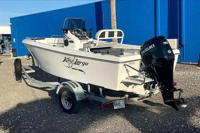 Slide: The Image of 2021 Key Largo 1800 CC boat with 90 HP outboard motor, docked in a marina. - 4