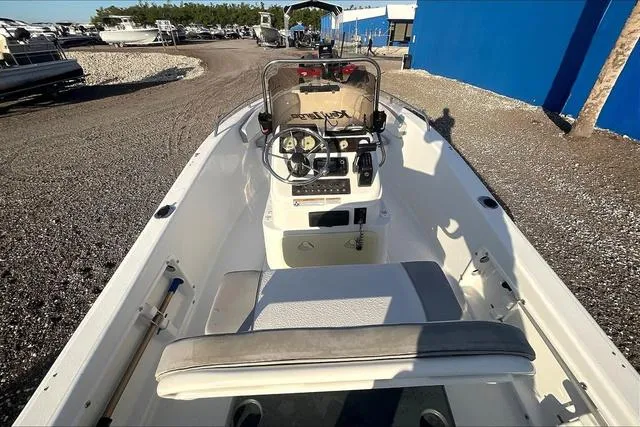 Slide: The Image of 2021 Key Largo 1800 CC boat interior with steering console and seating, parked on gravel. - 8