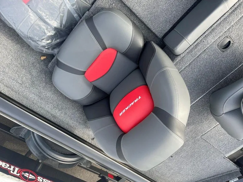 Slide: The Image of 2025 Tracker Pro Team 175 TXW® boat seat, gray and red design, on carpeted deck. - 12