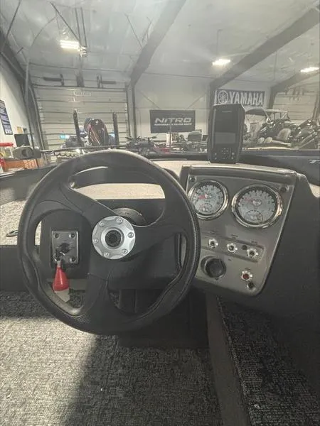 Slide: The Image of 2025 Tracker PG V16 SC boat dashboard with steering wheel and gauges in a showroom. - 6