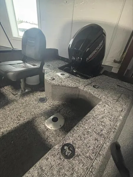 Slide: The Image of 2025 Tracker PG V16 SC boat interior with Mercury engine, featuring seating and carpeted flooring. - 7