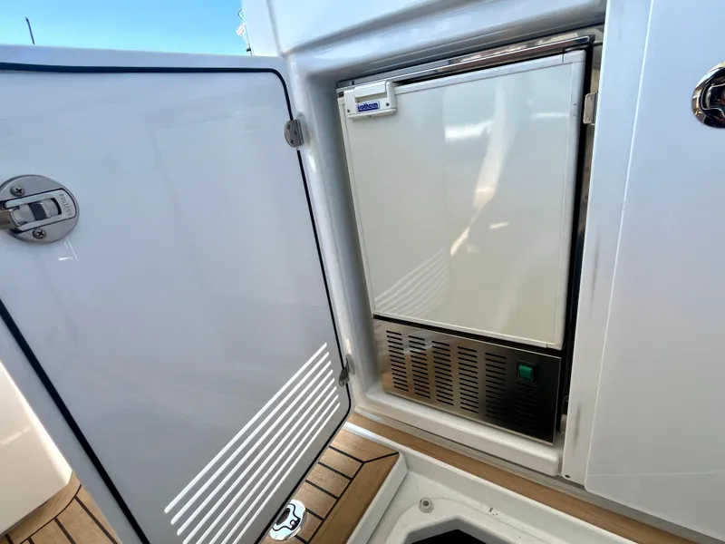 Slide: The Image of Beneteau Gran Turismo 41, 2023 model, featuring a built-in refrigerator with open door. - 25