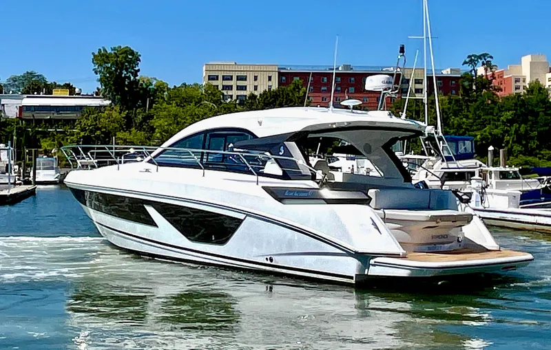 Slide: The Image of 2023 Beneteau Gran Turismo 41 yacht docked in a marina, surrounded by buildings and trees. - 5