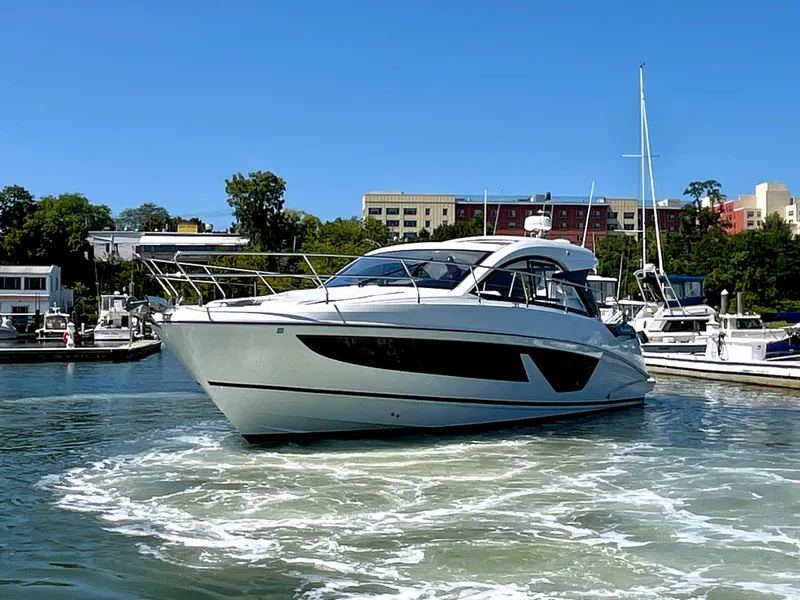 Slide: The Image of 2023 Beneteau Gran Turismo 41 yacht cruising in a marina under clear blue skies. - 8